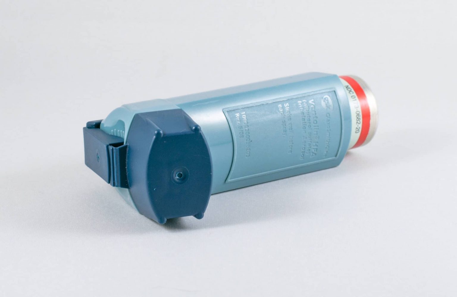 A blue plastic asthma inhaler on its side