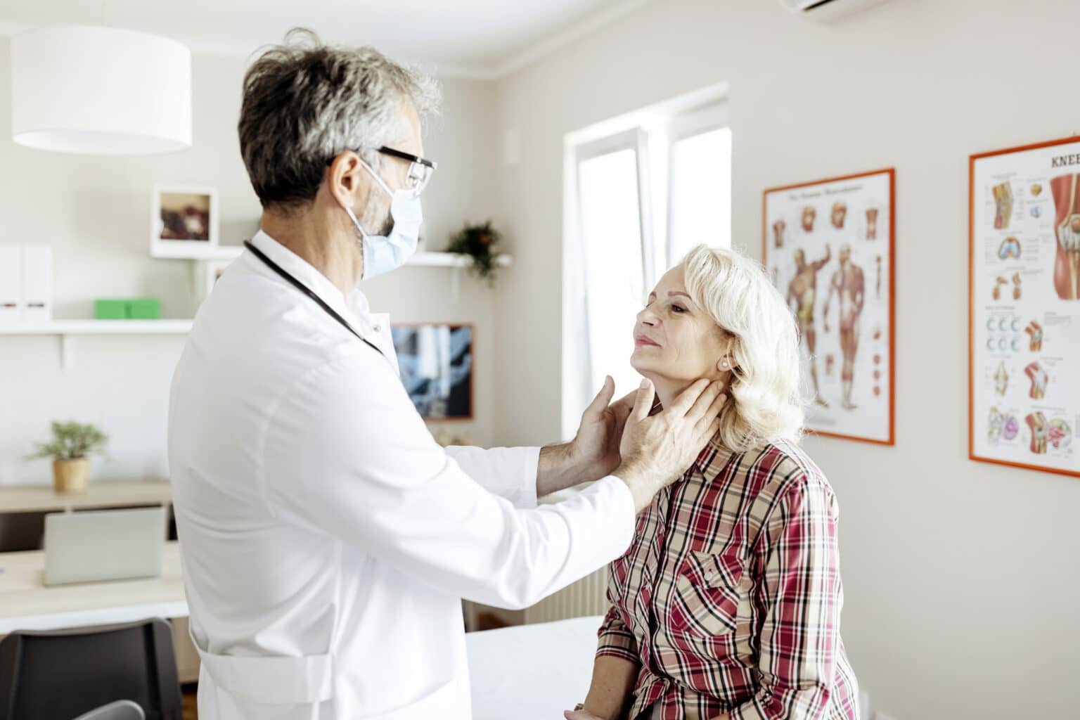 Shot of a male doctor examining a senior female patient in his medical office