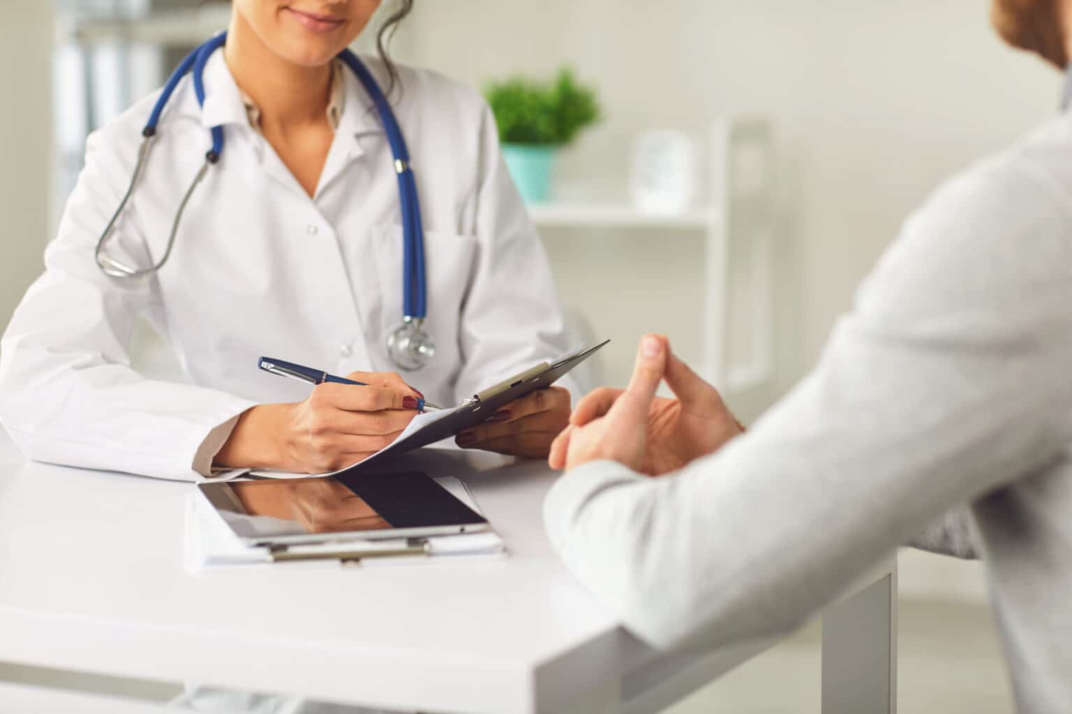 A doctor speaks with her patient in an ENT medical office setting.