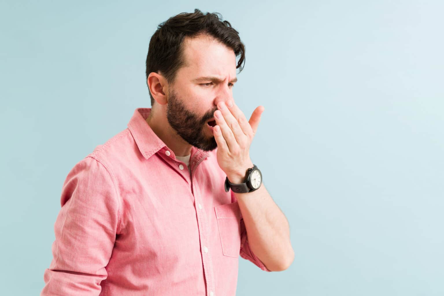 Man checking his breath to see if it's bad.