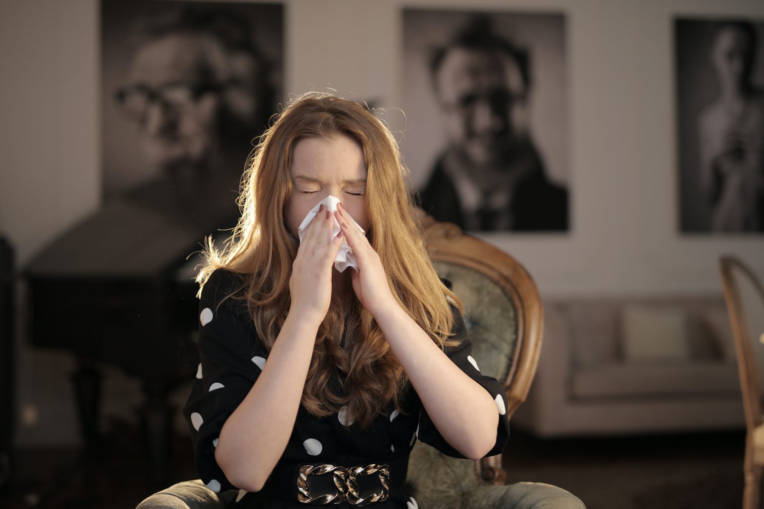 Woman blowing her nose into a tissue.