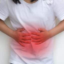a young girl holds her stomach in discomfort