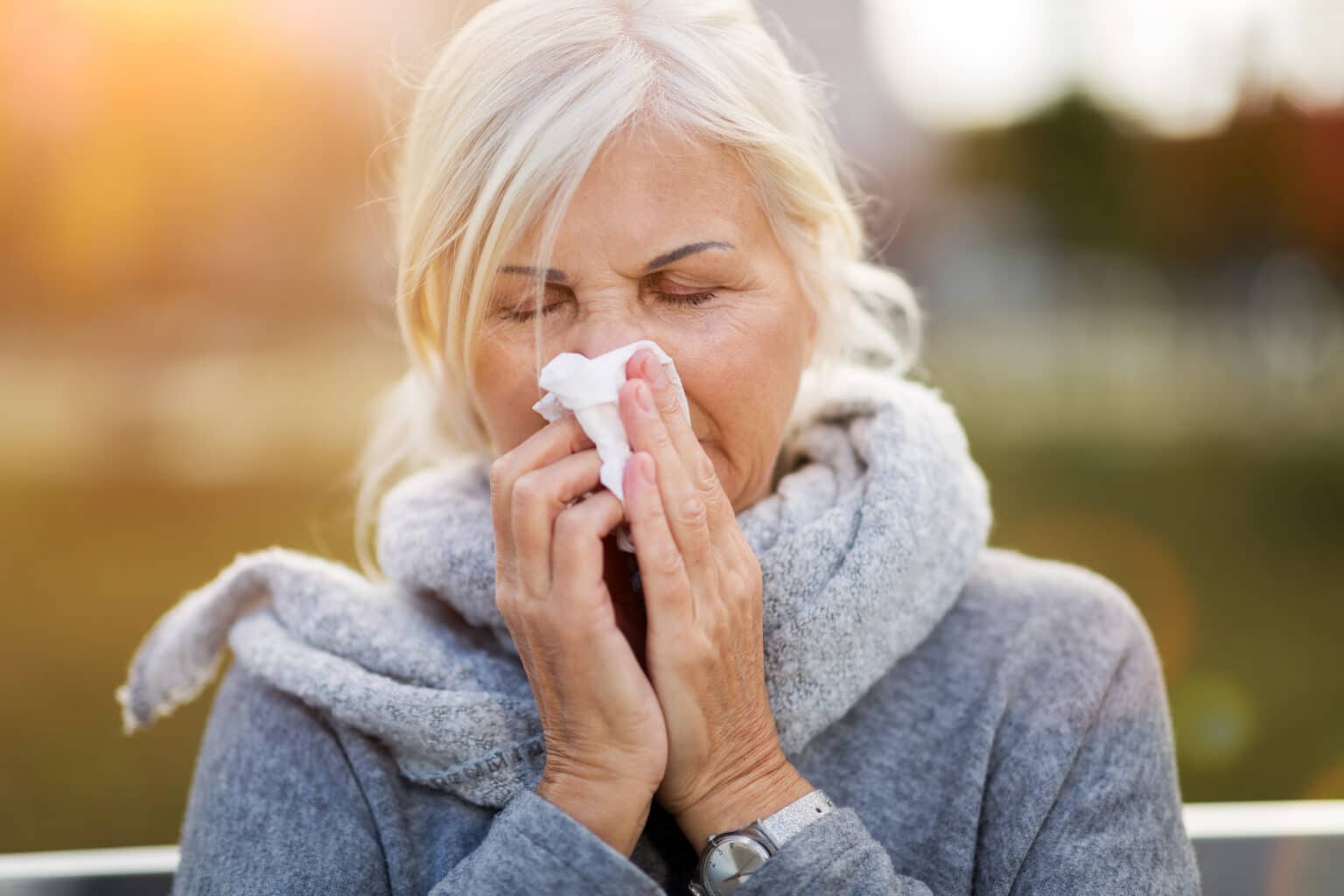 Senior woman blowing her nose.