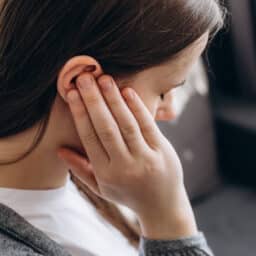Woman holding her ear with an ear infection