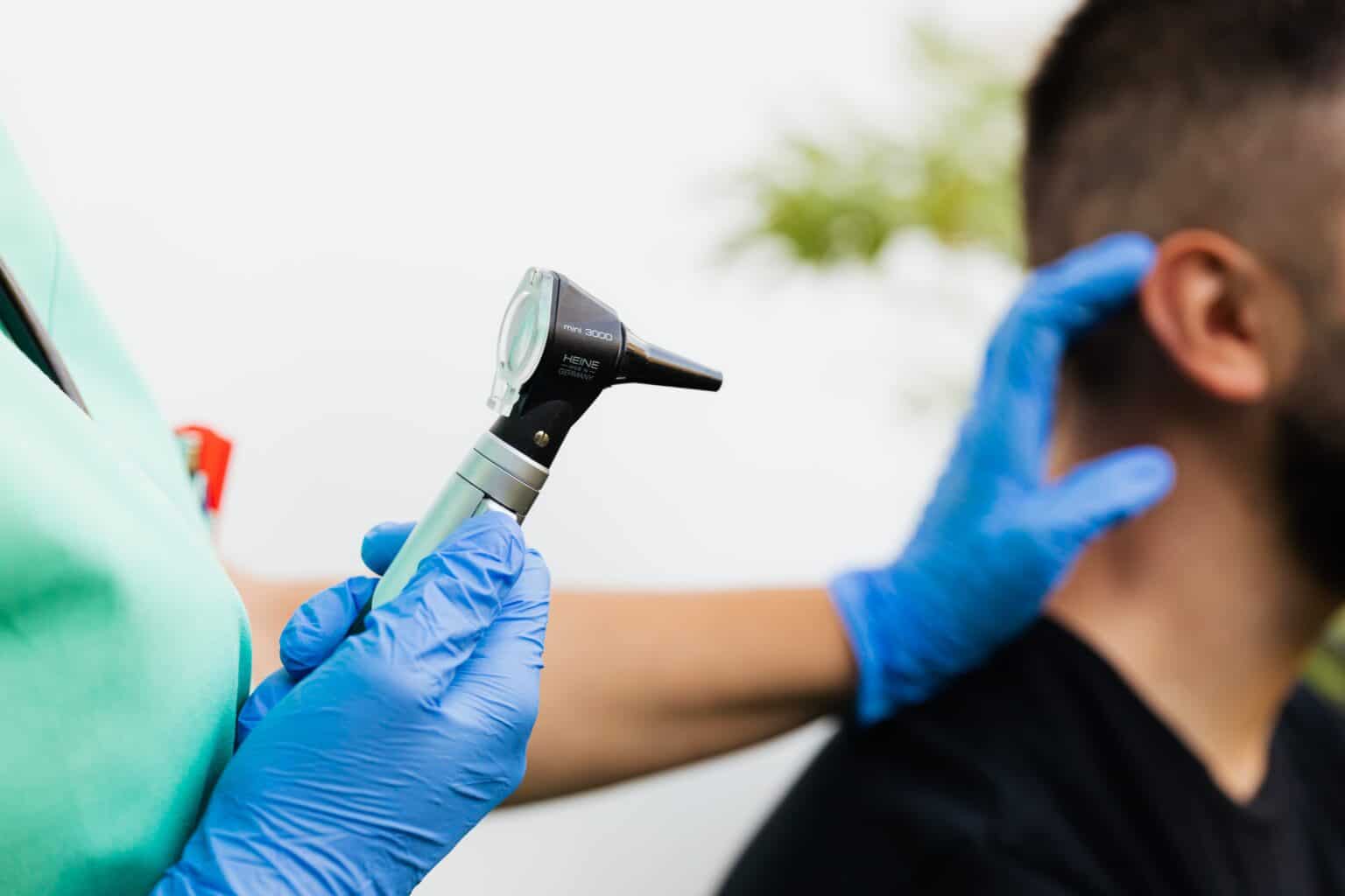 Doctor examining a man's ear.