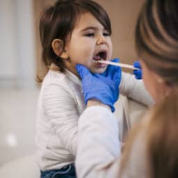 Young girl getting her tonsils looked at by a doctor
