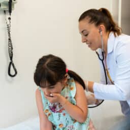Coughing child being examined by a doctor
