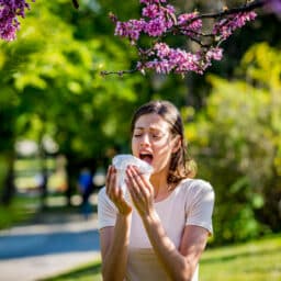 Woman sneezes from allergies