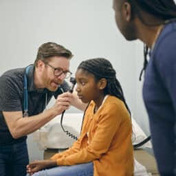 ENT examining a young girl's ear