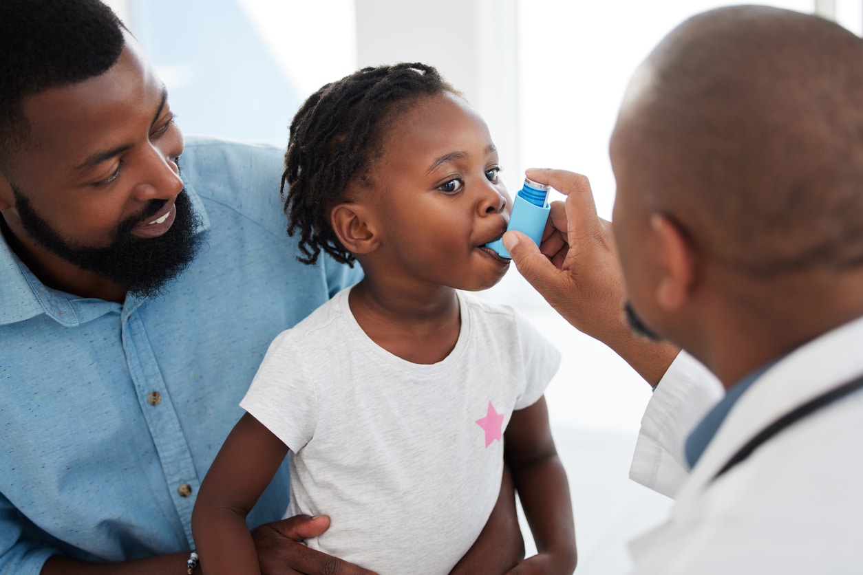 Doctor administers inhaler for a young child