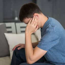 Young man holding his ear