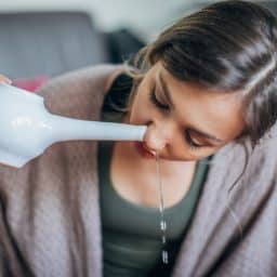 Woman using a teapot to irrigate her sinuses