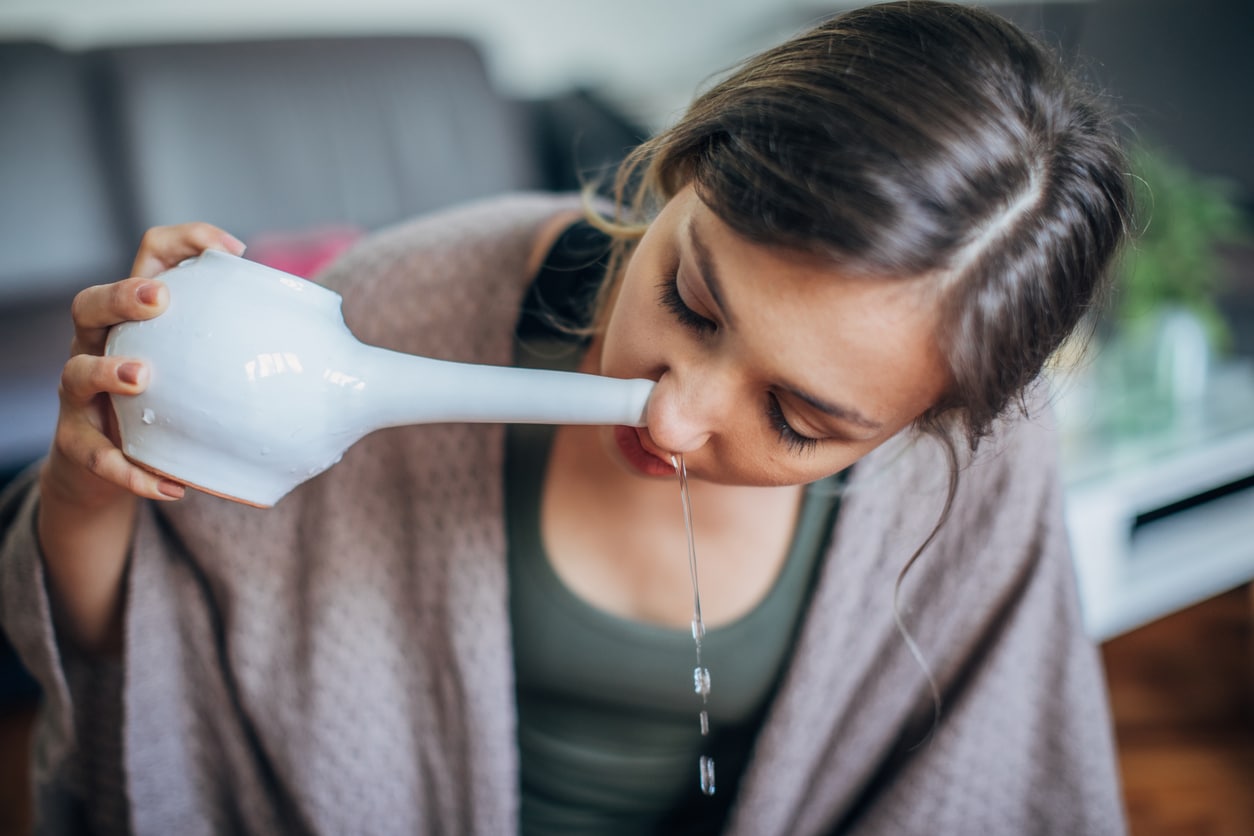 Woman using a teapot to irrigate her sinuses.