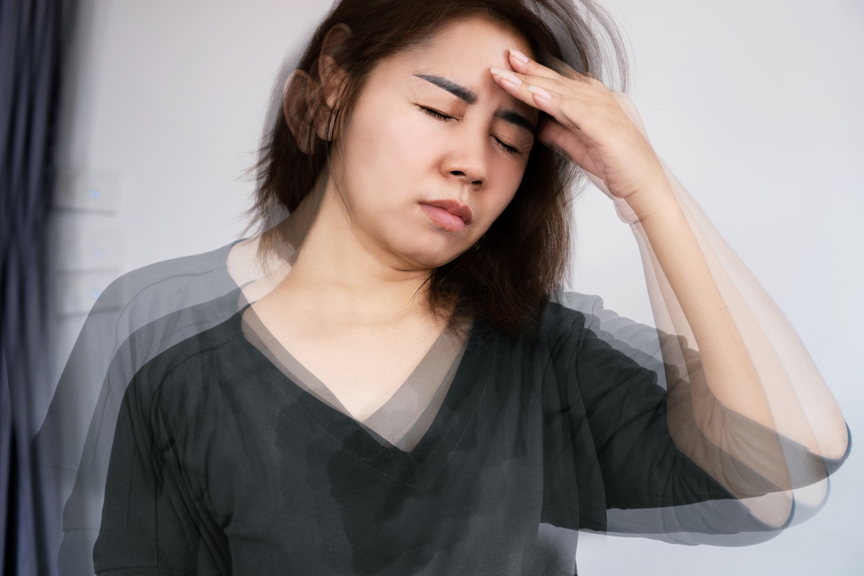 Woman with vertigo feeling dizzy holding her head.