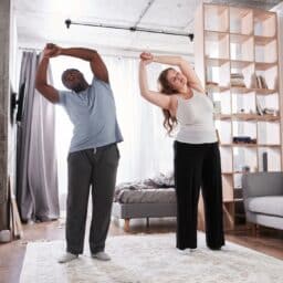 Couple doing balance exercises in their home.