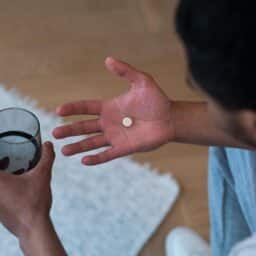 A person suffering from allergies takes medication to alleviate symptoms.